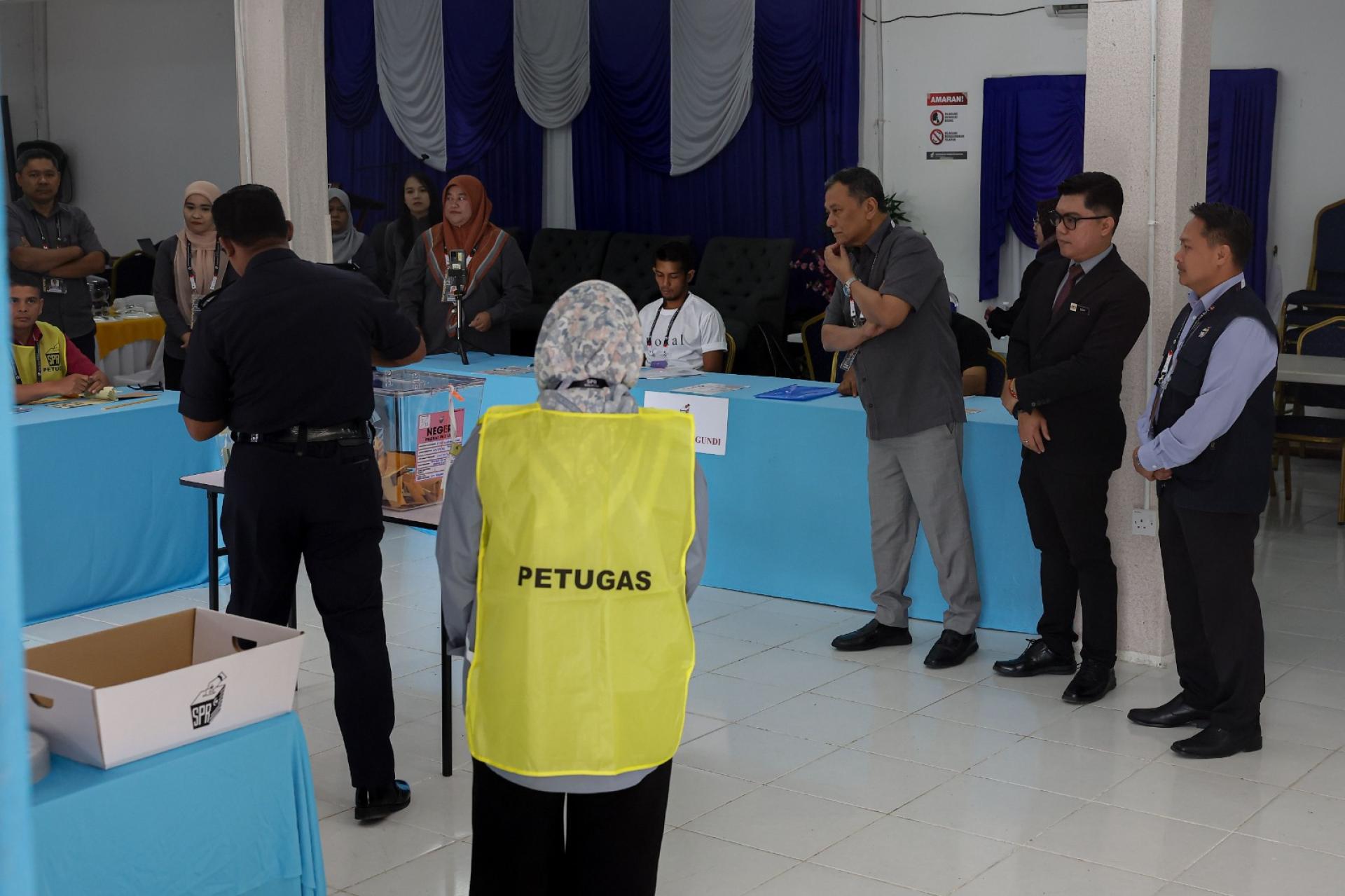 南兰哈伦（右3）巡视提前投票中心。