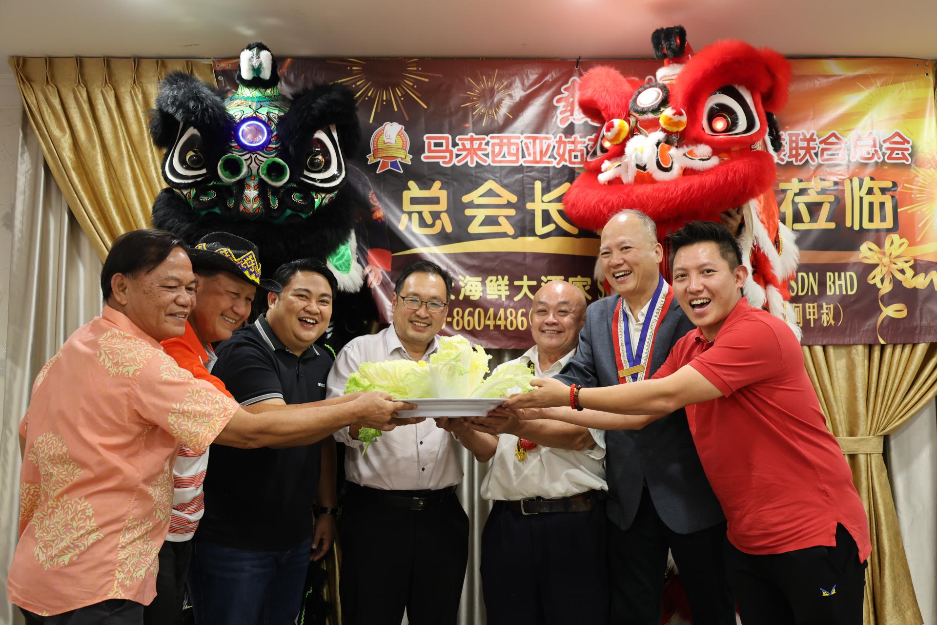 张健仁(中)与江泽甲（右3）、杨万强（右2）、其特别助理沈杰龙（右1）等受邀嘉宾共同喜接瑞狮菜青福品。