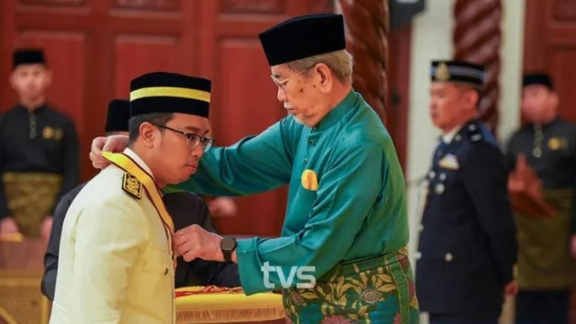 阿兹祖尔（左）在古晋砂拉越州立法议会大厦举行的授勋典礼上，从州元首敦旺朱乃迪手中接领砂拉越犀鸟勋章（J.B.K）。