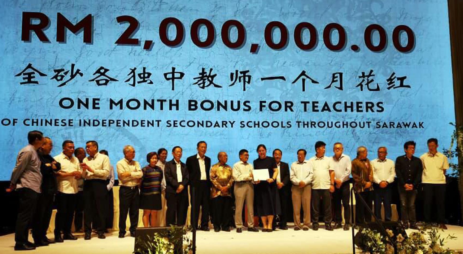 廉律中学校长江佩娟领取启德行集团捐献的一个月花红。