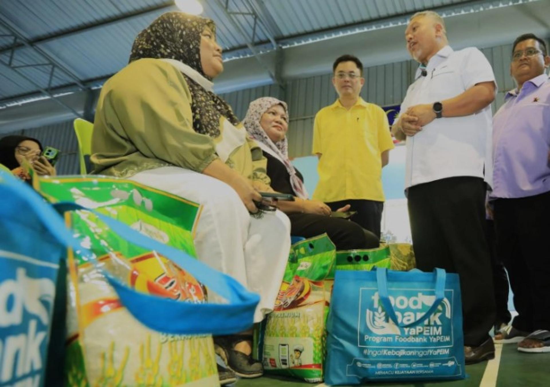 扎比迪（右2）与陈开（中）在砂拉越州级水灾、教育及返校援助活动中，亲切慰问受惠者。