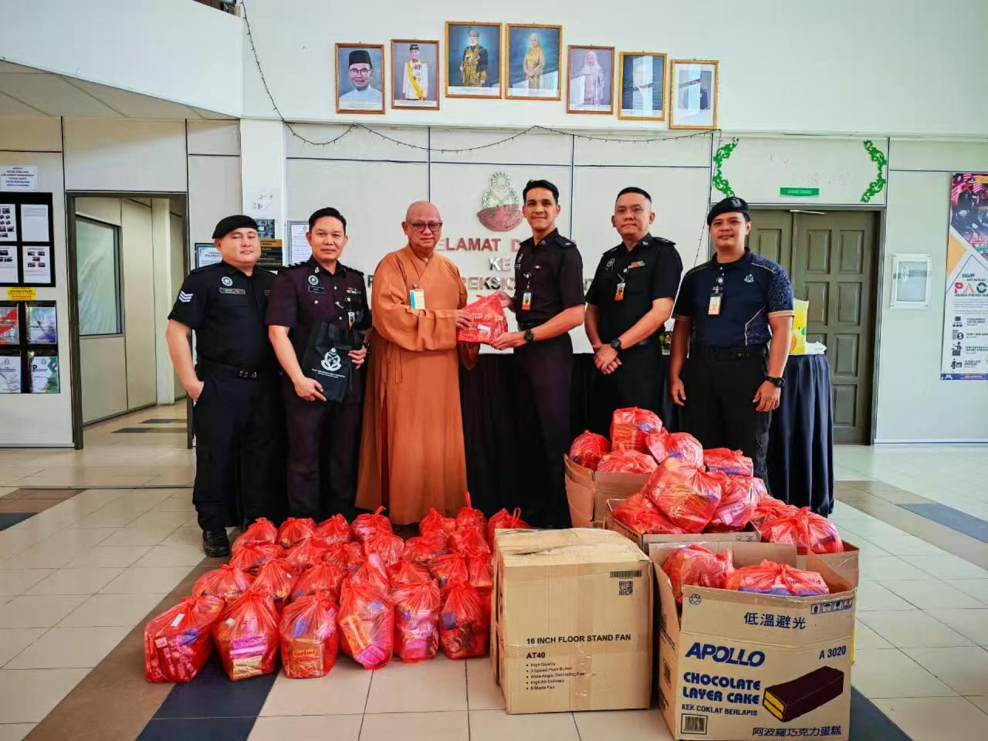 美里佛教會主席兼监狱弘法法师圣林法师（左3）移交新年礼物给民都魯监狱副主管萨希拉合影。