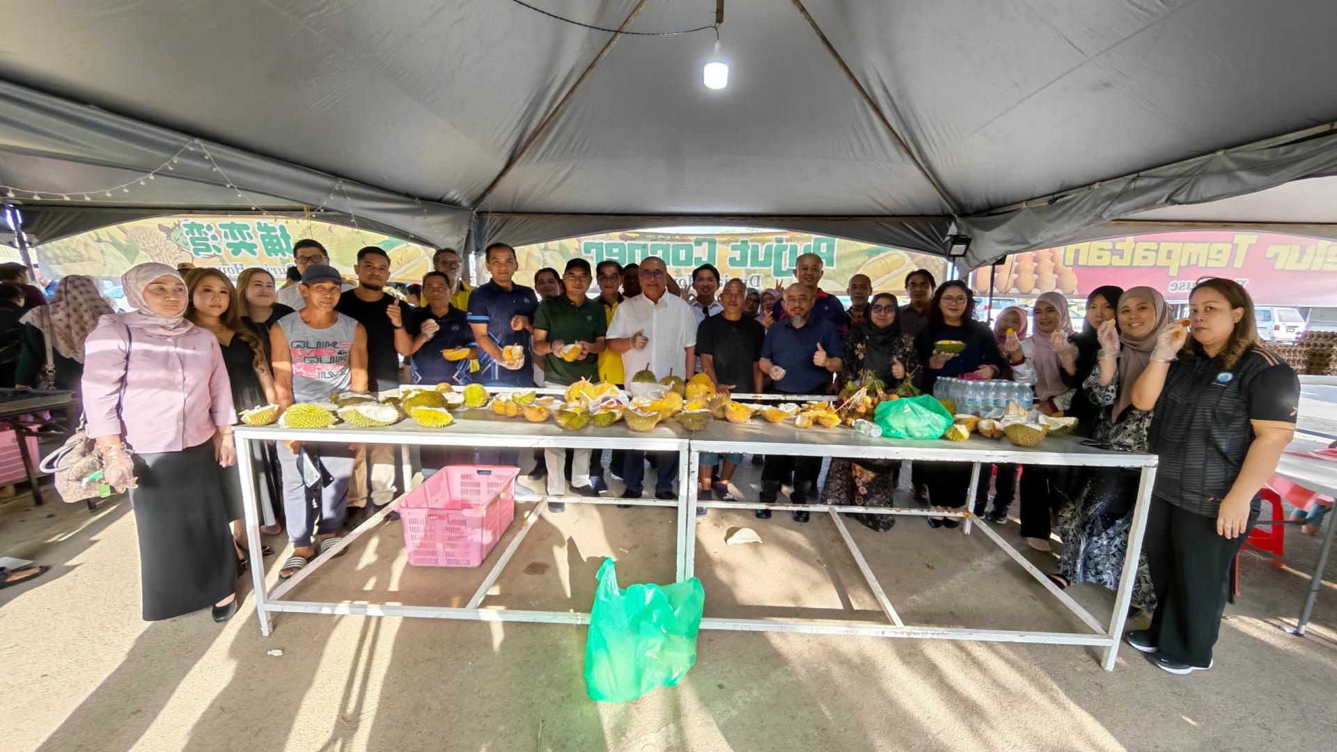 霹雳宜力县议会主席兼宜力县长莫哈末费德里哈山（左8）在美里市长俞小珊（左9）、副美里市长阿里芬（右8）及美里市议员及官员陪同下，于埔奕湾旧长途巴士总站的季节性水果中心品尝本地时令水果合影。