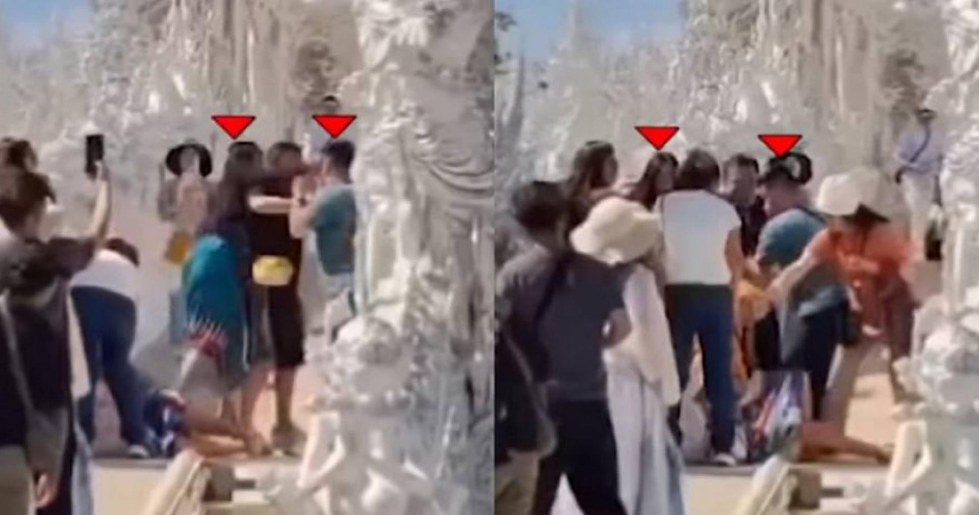 两对情侣在白庙内一个狭窄的桥上互相扭打，一旁还有许多游客驻足。