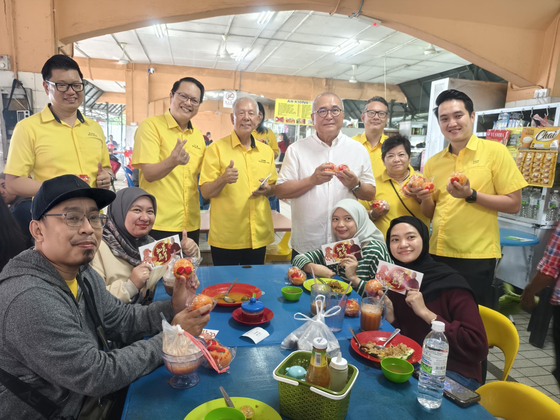 砂人联党美里3支部团队走访亲善小贩中心向市民派送年柑活动合影。左起为埔奕支部组织秘书兼市议员范宏祥、人联党史纳汀支部秘书彭小菶、美里卑尔骚支部主席拿督陈超耀、埔奕支部主席俞小珊、美里市议员余忠明、珠巴分部妇女组主任黄金凤及埔奕支部青年团团长许勋扬。