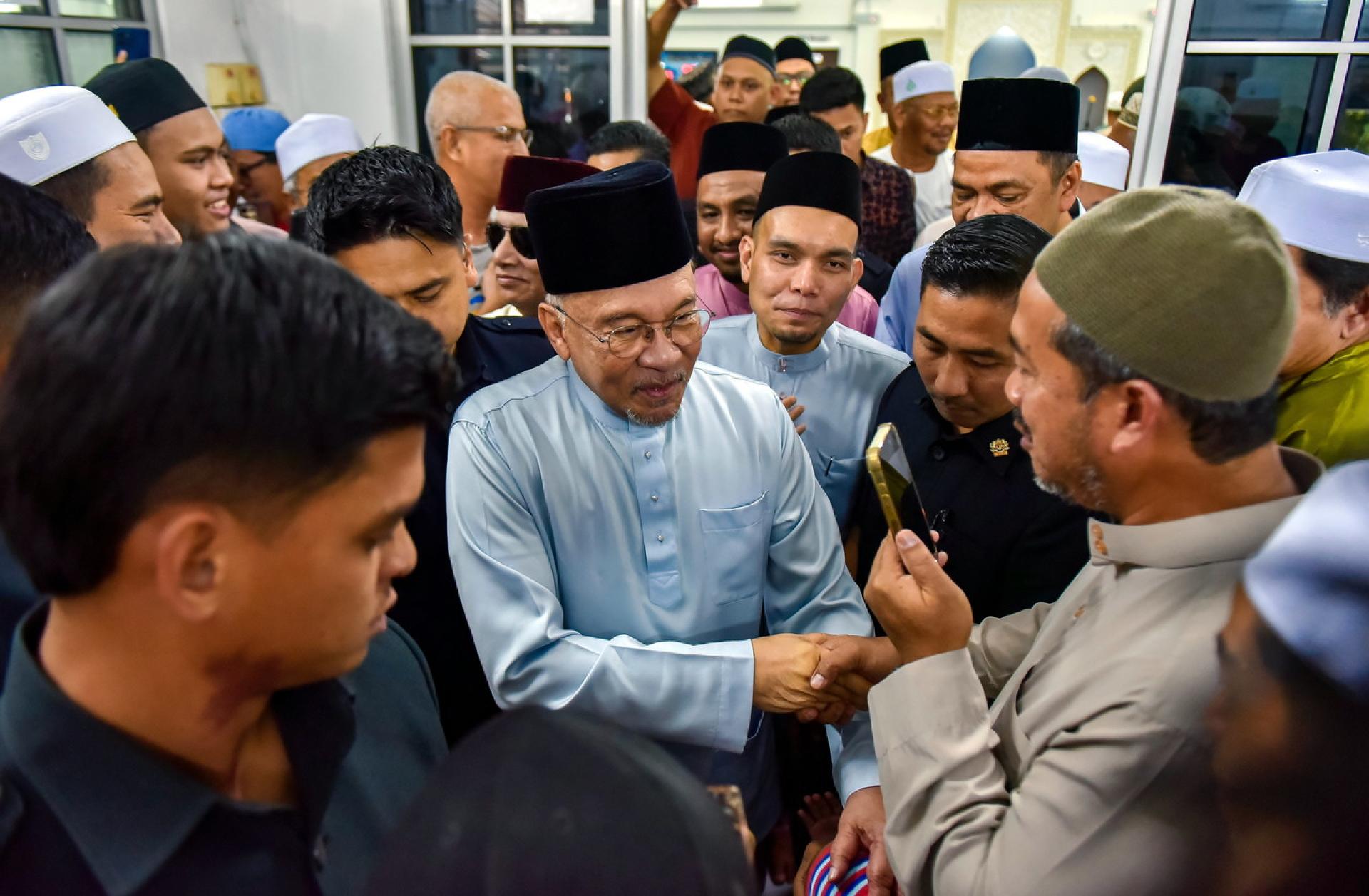 安华（左2）周五到万宜第8区清真寺进行周五祈祷，或当地民众热烈欢迎、