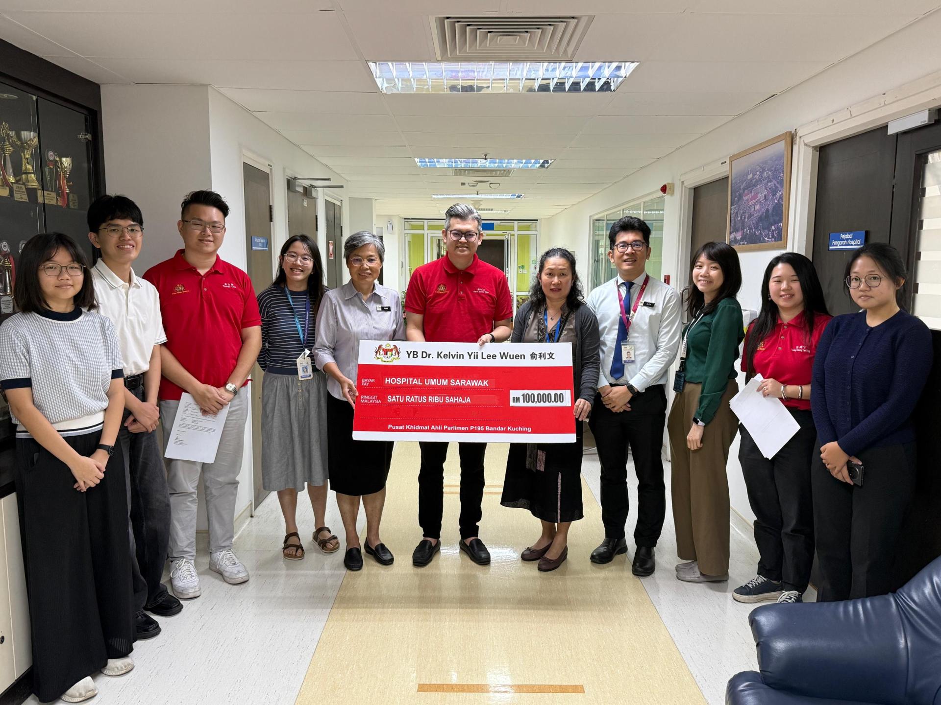 古晋市国会议员俞利文（中）移交10万令吉选区拨款予砂拉越中央医院，用于添购设备及设施。