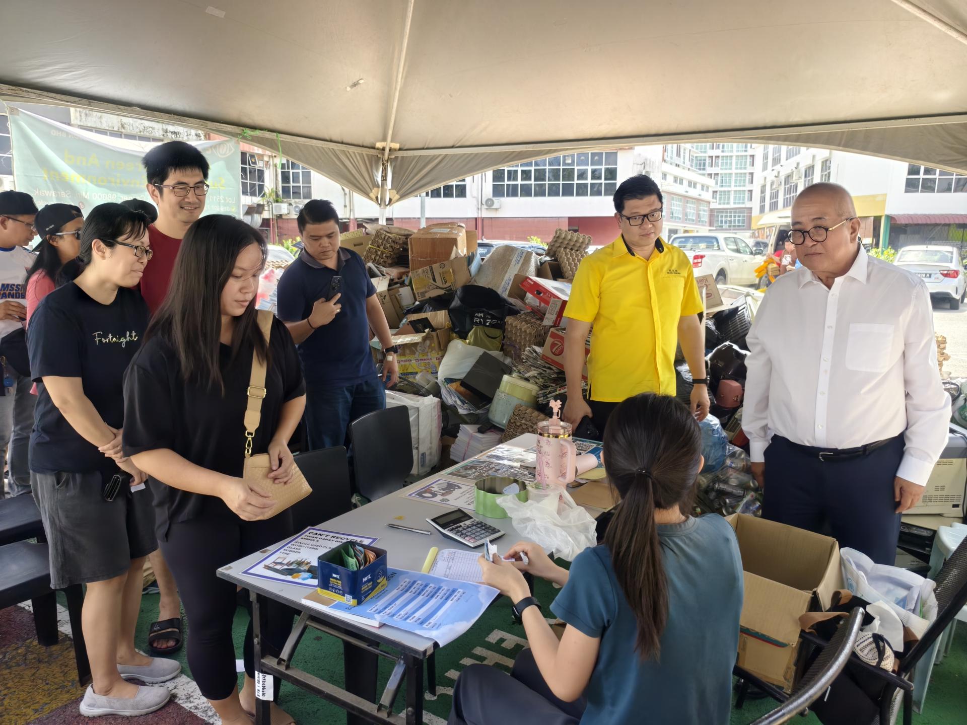 俞小珊（右）巡视美里绿色社区中心“回收再购买”活动现场，了解可回收物情况，鼓励市民积极参与环保行动。右2为美里市政局旅游发展工作小组主席兼美里市议员范宏祥。