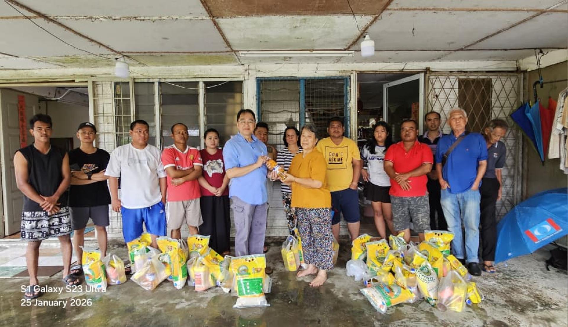 黄锦河律师（左5）今早在人民公正党古晋区部数名领袖的陪同下前往石角路干榜苏利伊班配送米粮食品给该干榜在上个月遭受水灾影响的木屋居民.