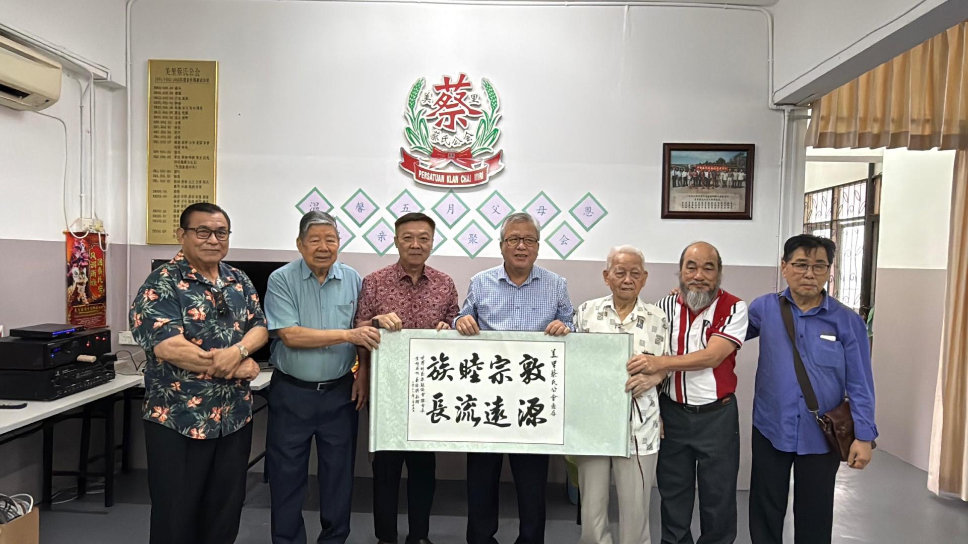 世总会长拿督威拉蔡德兴（右4）赠送墨宝于美里蔡氏公会，由主席蔡明敏（左3）接收。