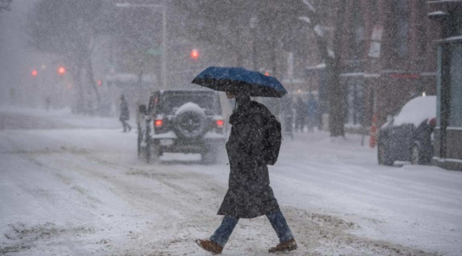 在马萨诸塞州波士顿的科普利广场，行人冒着暴风雪过马路。
