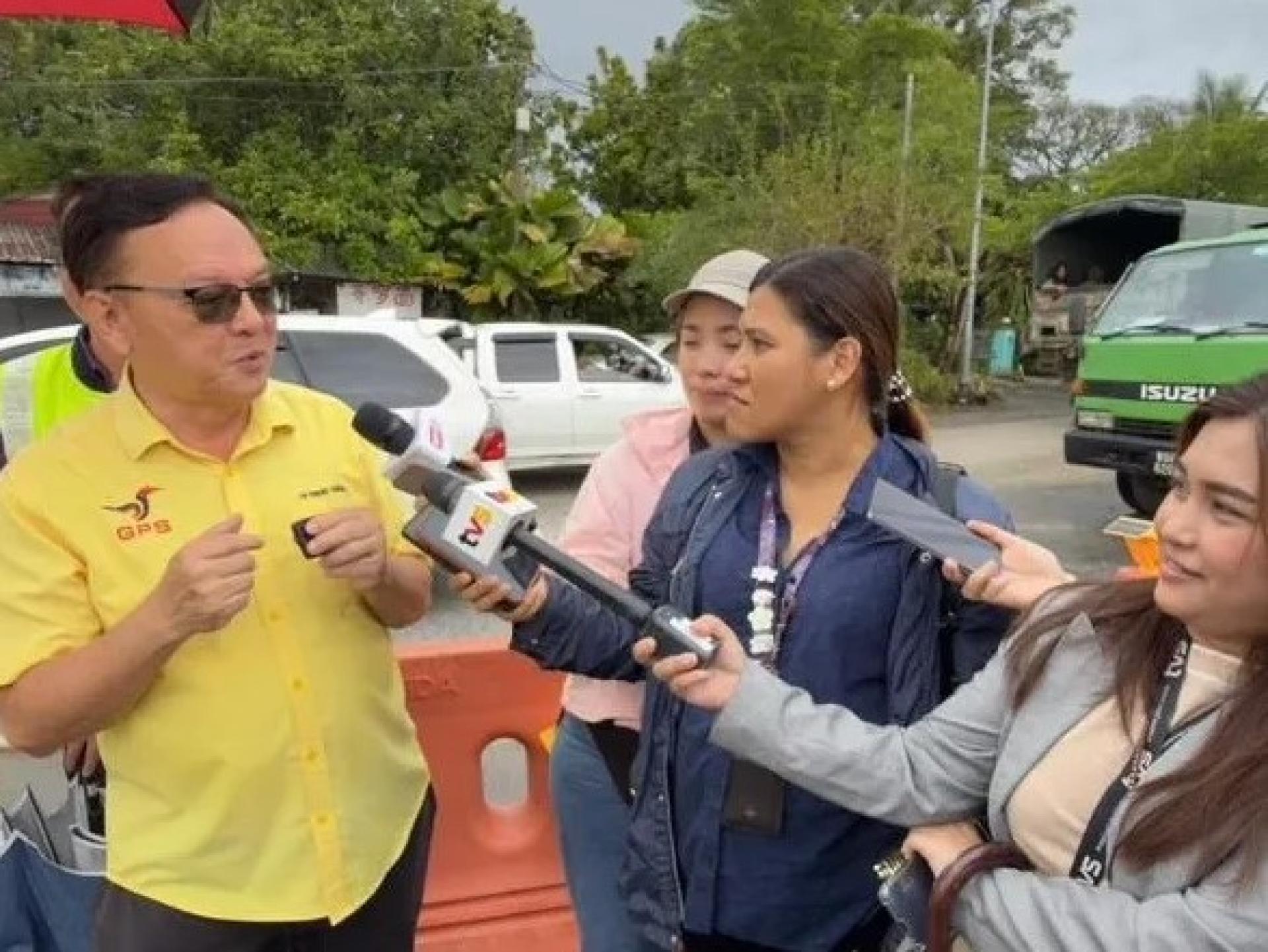 2026年1月26日，罗克强（左）在古晋巴都吉当路进行现场视察时向记者说明情况。