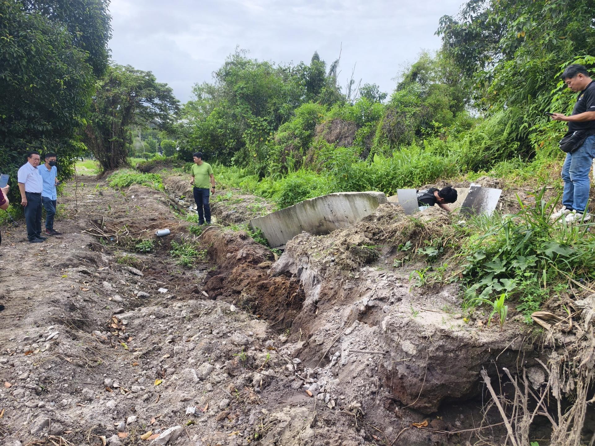 砂拉越交通部长兼史纳汀区州议员拿督斯里李景胜（左）今早巡视廉律路山边、冠军羽球馆对面的排水沟坍塌情况，了解侵蚀程度及潜在安全风险，刚好遇到热心人士蔡枚芙在义务进行维修。