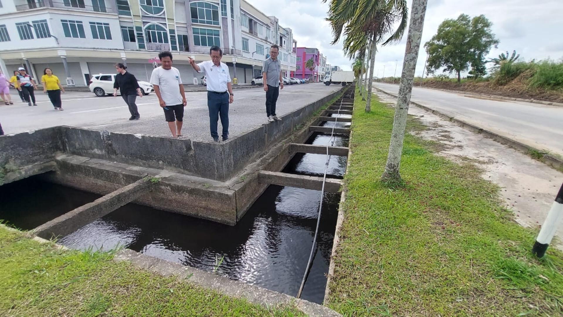 砂拉越交通部长兼史纳汀区州议员拿督斯里李景胜（中）今日下午率领史纳汀区服务团队，前往迪沙史纳汀水患重灾区，巡视当地排水沟清理工程的进展。