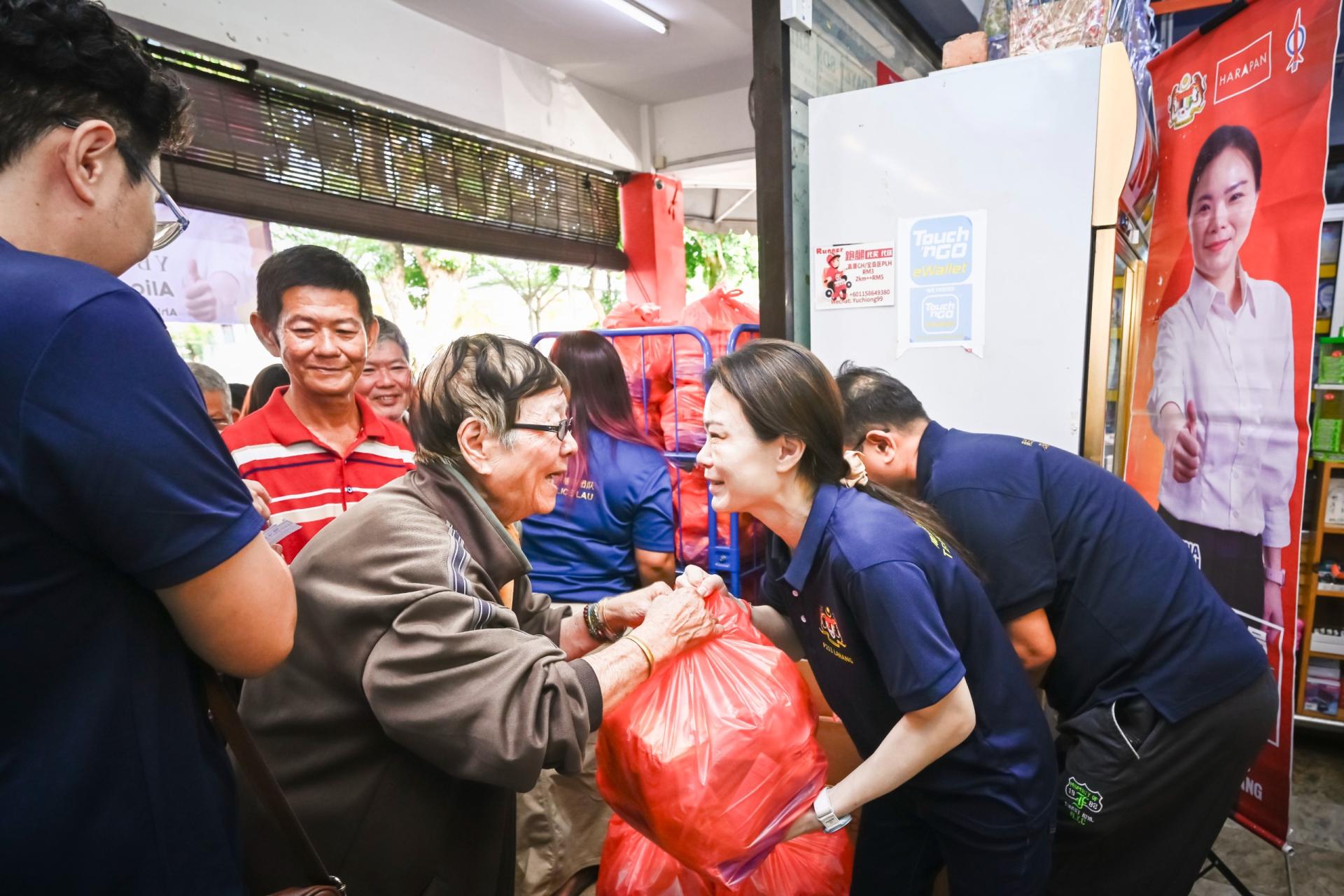 南兰区国会议员刘强燕（右）移交食品配套予一名受惠民众。（档案照片）