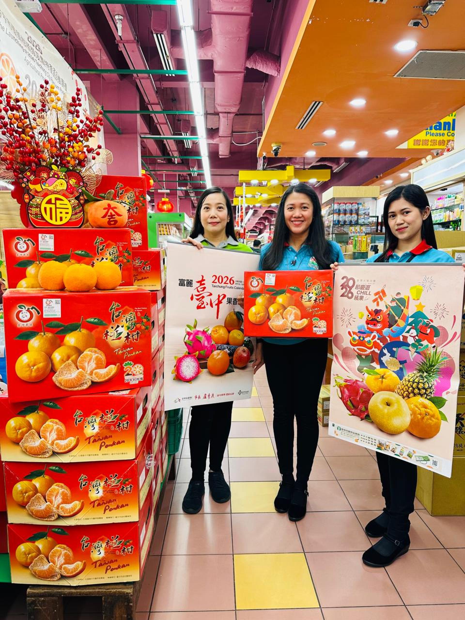 第一百货超级市场（摩拉分行）职员展示精美月历及台湾椪柑
