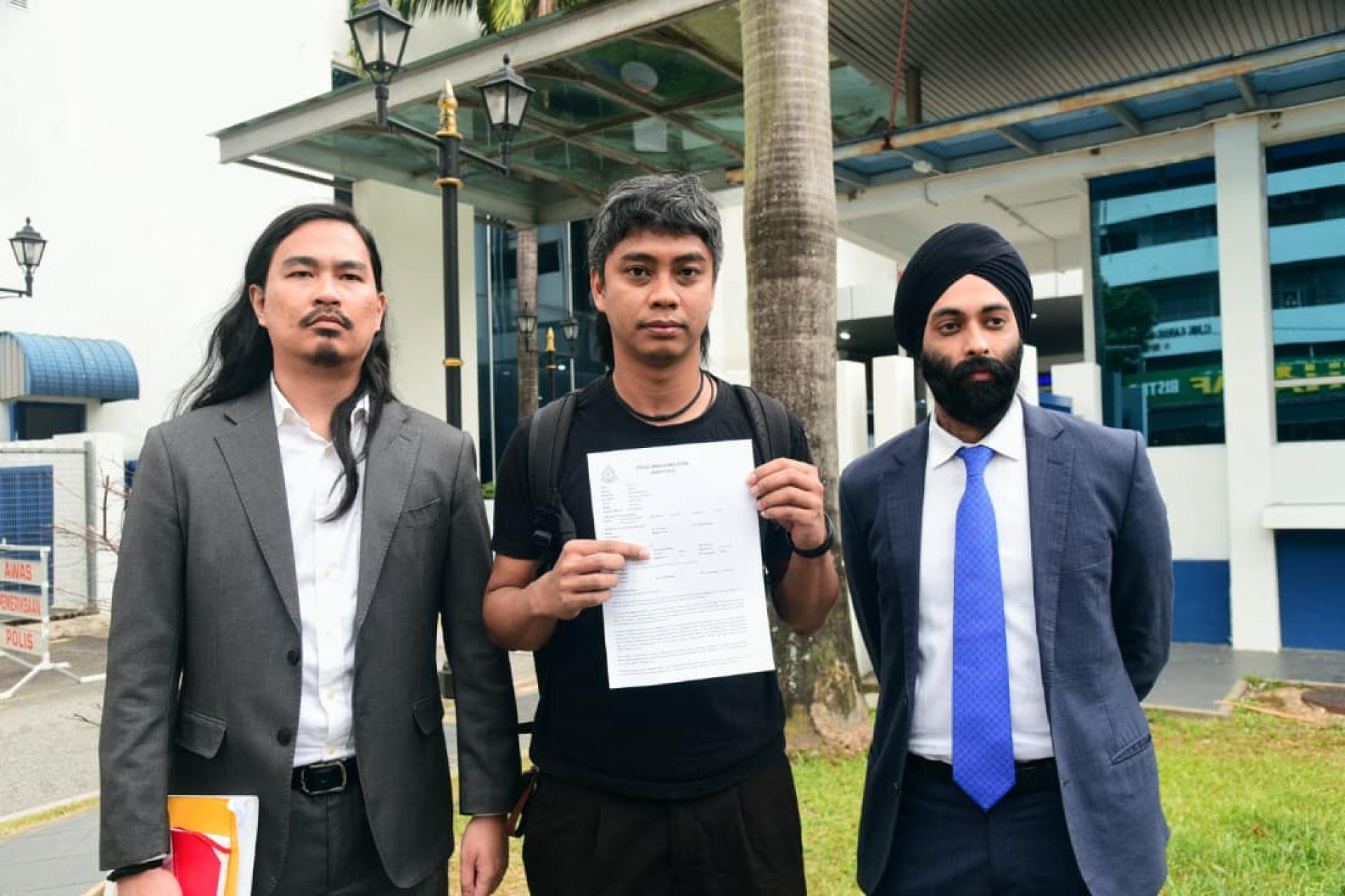 黄勤辉（中）出示报案纸，左起再益马烈（左）与马哈佐星。