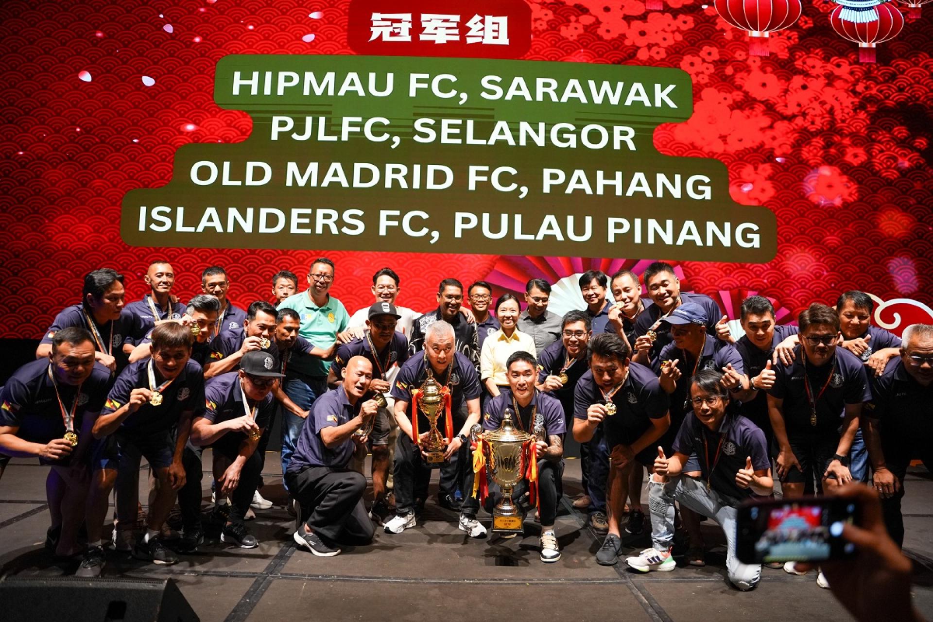 冠军队来自砂拉越的HIPMAU FC队的全体队员和负责人在台上领奖后和主宾代表及贵宾欢喜大合照。