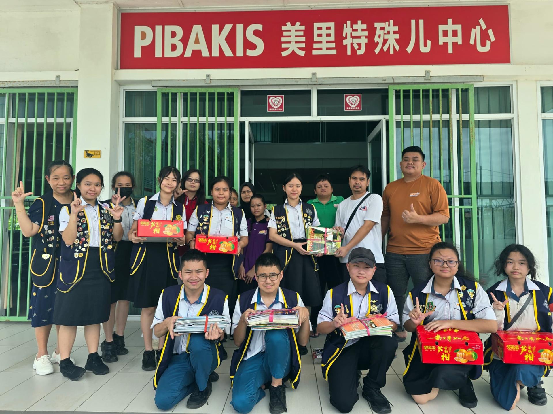 廉中幼师会筹委会主席蔡秀芳移交柑橘与书籍予美里特殊儿中心中心负责人。