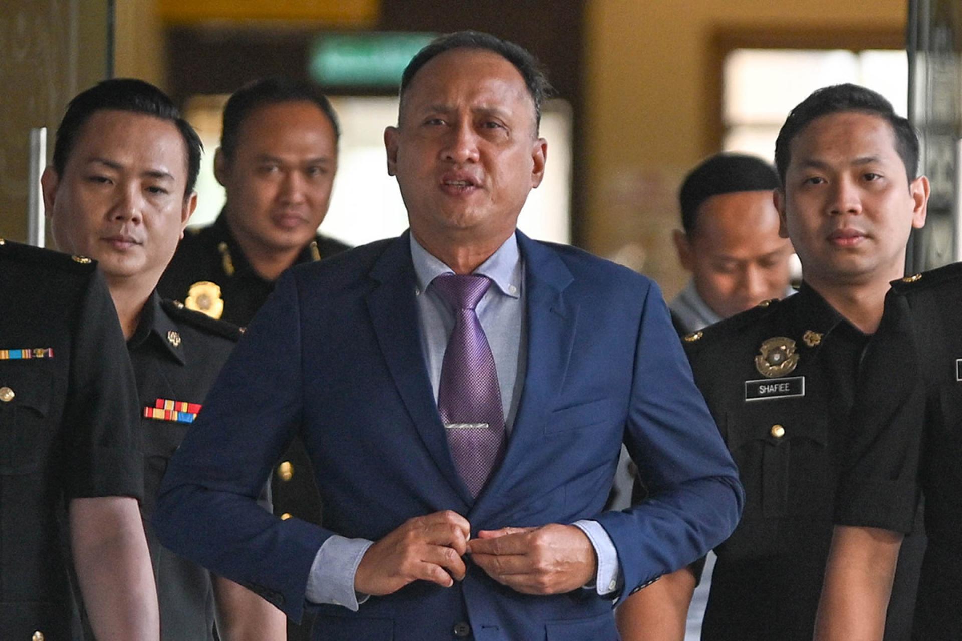 莫哈末弗兹在反贪会官员陪同下抵达地庭。他身穿深蓝色西装，神情从容，步入法庭前还向媒体微笑并简短问候：“今天好吗？”