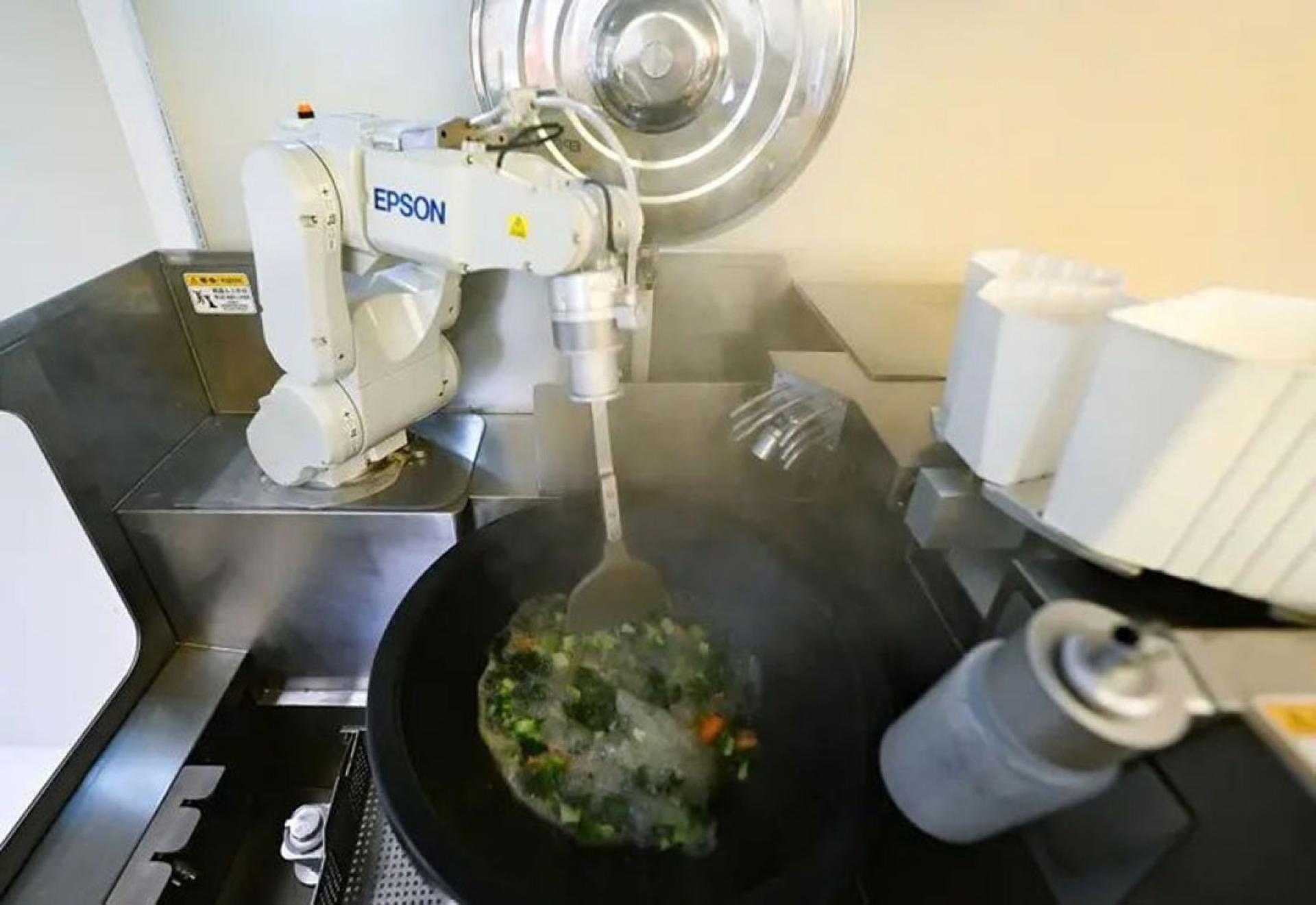 浙江杭州“二十四节气AI机械人餐厅”26日正式开业，机械人正烹饪蔬菜。（图：中新社）