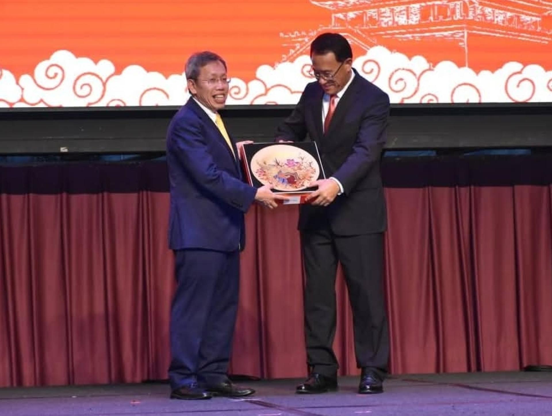 中国驻古晋总领事邢伟平（右）赠送纪念品给砂总理阿邦佐哈里的代表，即副总理拿督阿玛沈桂贤。