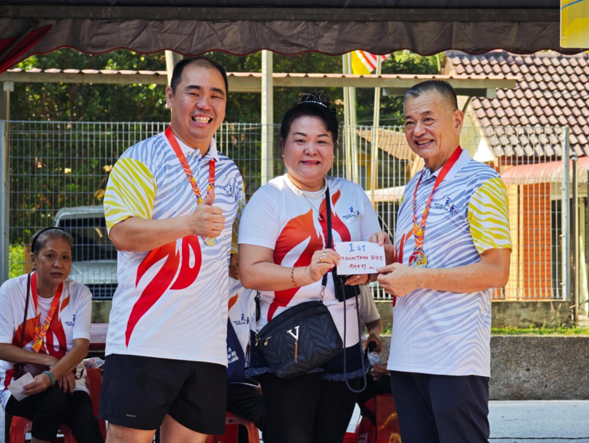 陈德钦（右）颁奖给获得幸运抽奖首奖的参与者，左为陈扬邦。