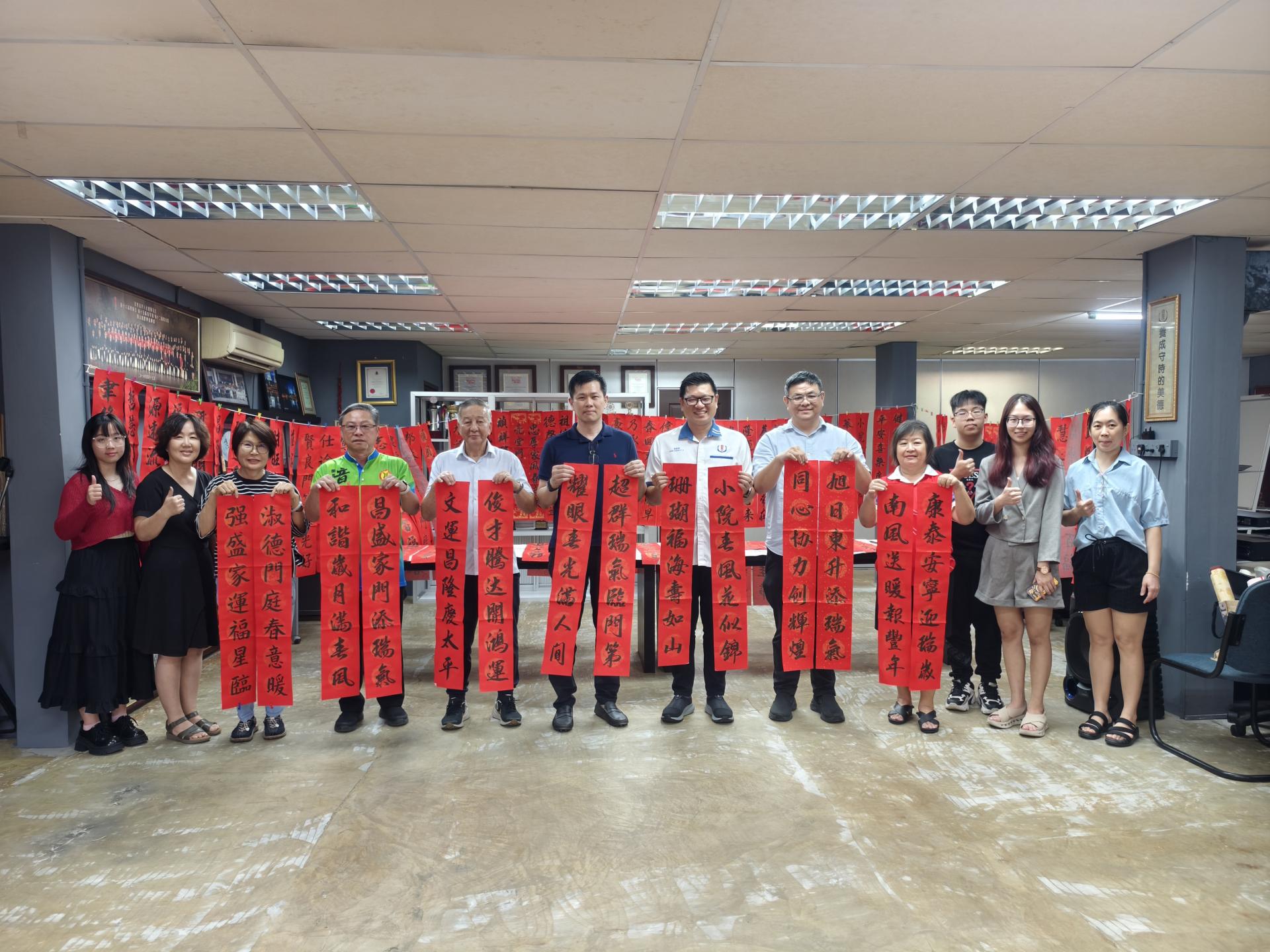 美里省华总会长许信隆（左6）与理事一行人，手持冠有受邀嘉宾名字的对联合影。