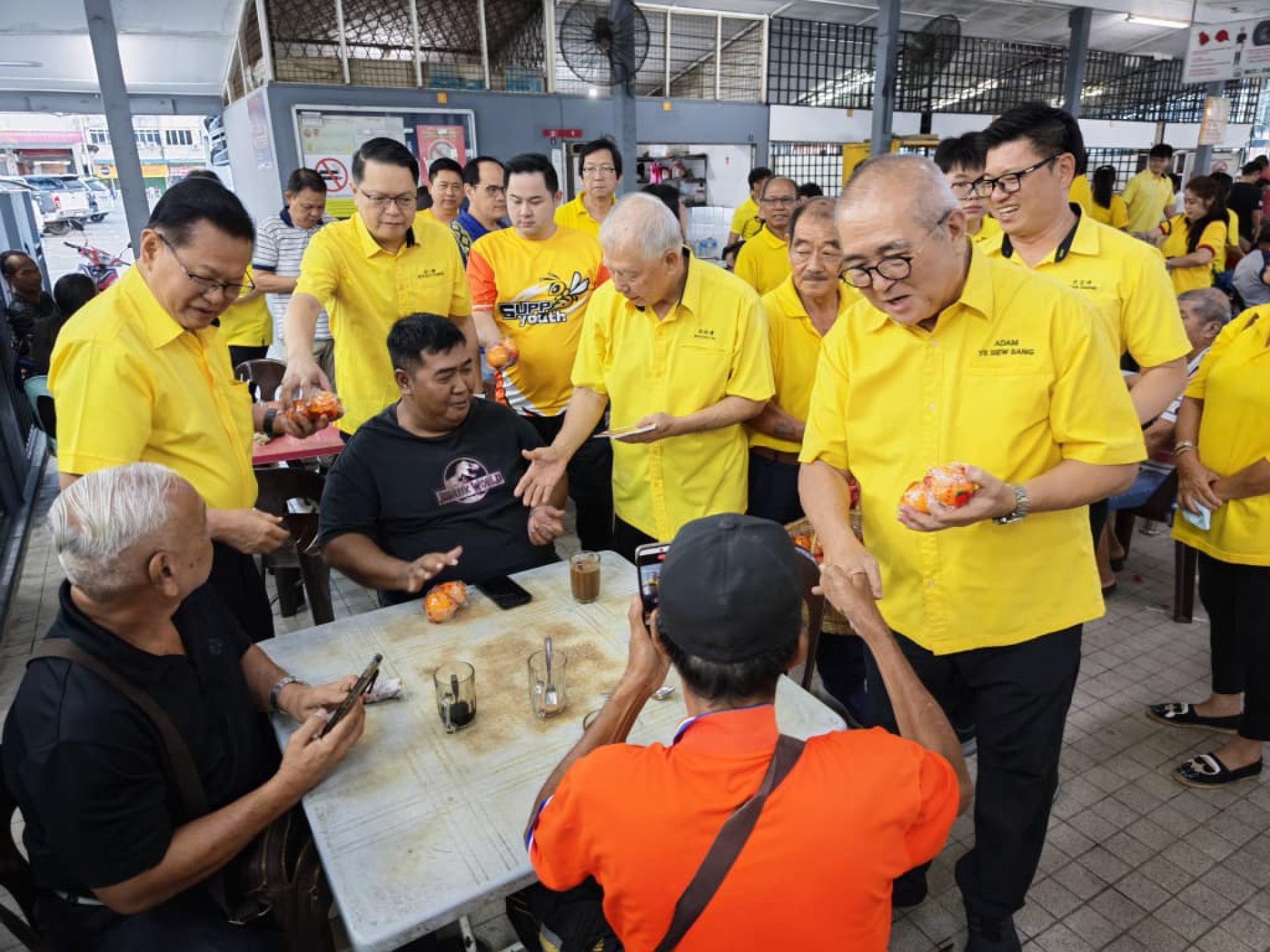 人联党史纳汀支部主席拿督斯里李景胜（左）、美里卑尔骚支部主席拿督陈超耀（右2）、埔奕支部主席俞小珊（右）与团队派送年柑给民众。