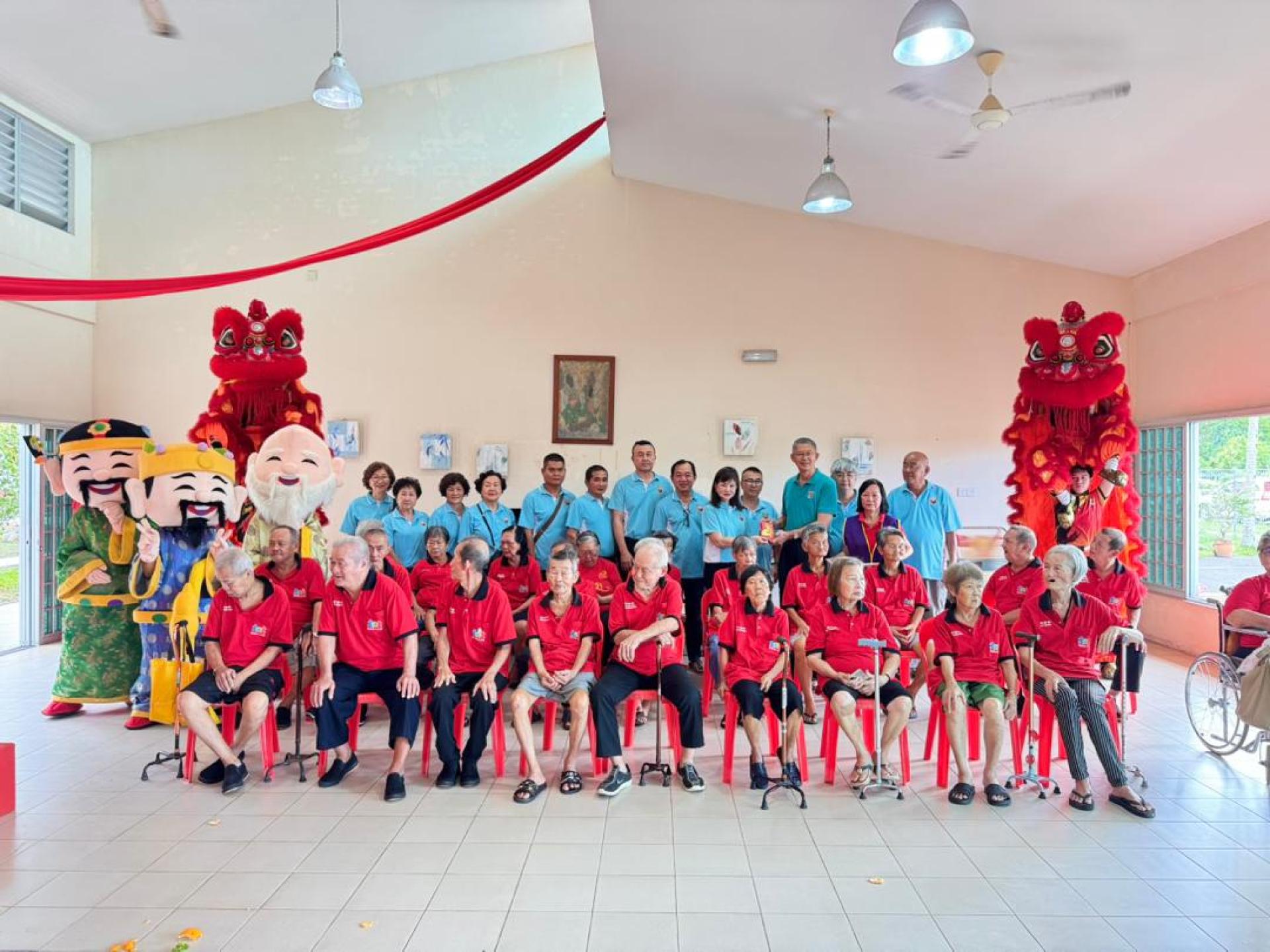 美里诏安会馆会长林美英率领理事、青年团、妇女组及乐龄组委员，前往美里老人之家派发红包与红柑，并与院内长者共进佳肴，提前欢庆农历新年。图为移交新春红包给美里老人之家副主任沈顺展（右4）。