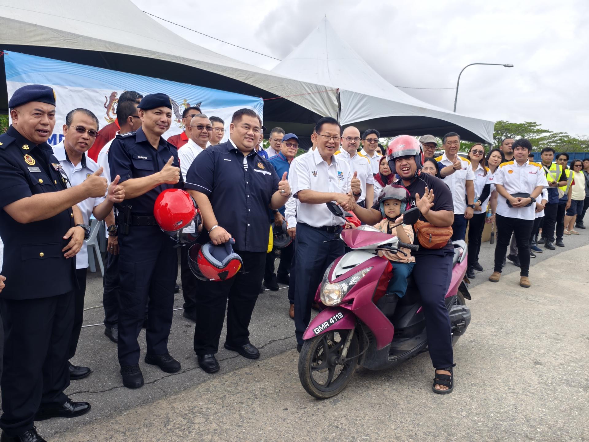 喜获新头盔的摩多骑士，开心得合不拢嘴。左3起为美里警区主任李炳强助理总监、砂拉越陆路交通局局长诺里占吉里及砂拉越交通部长拿督斯里李景胜。