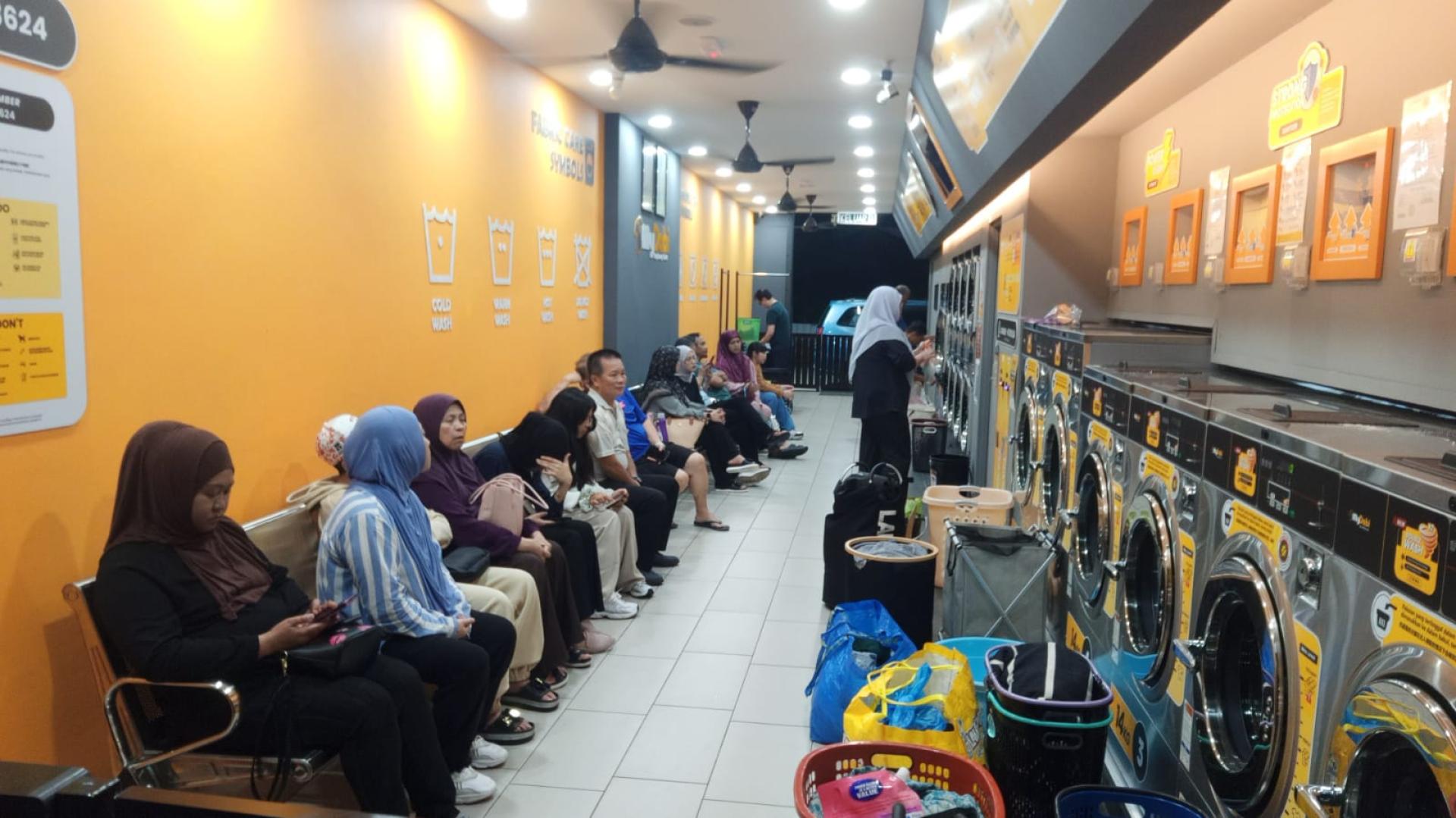 客户在遮鲁东一间自助洗衣店清洗衣物