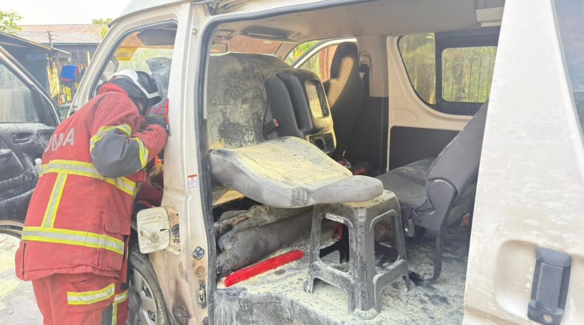 消防员在检查被烧毁的车辆。