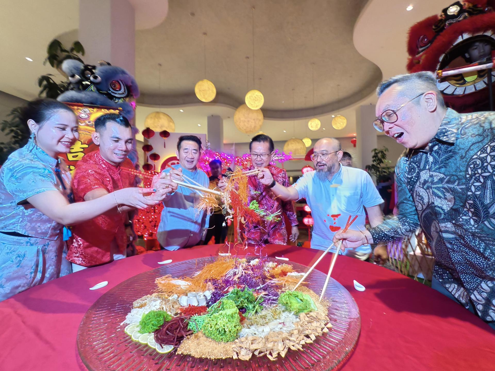 拿督斯里李景胜（右3）与嘉宾一同进行“捞生”，互道新春祝福，现场洋溢喜庆气氛。右2为副美里市长俞小珊。