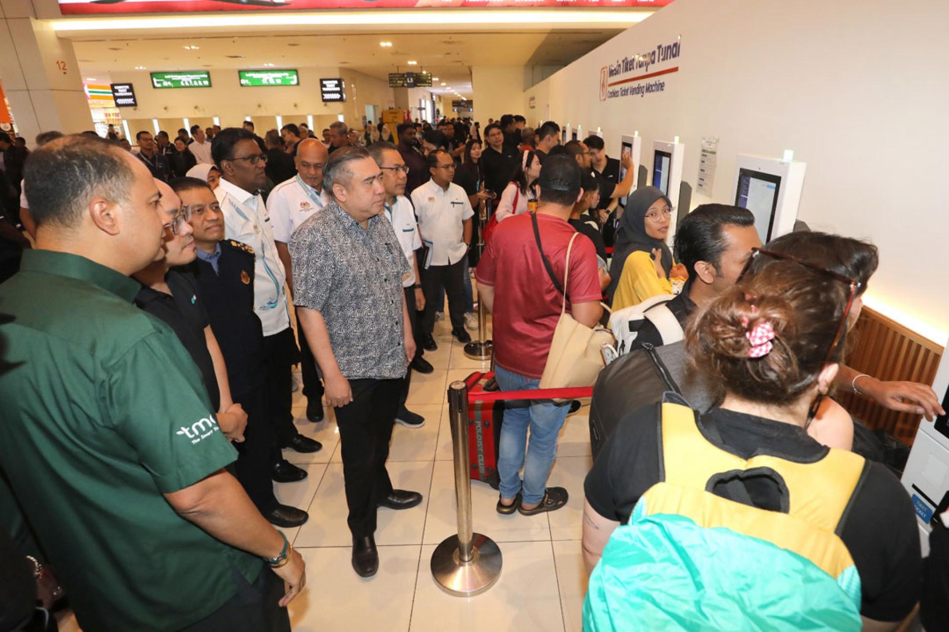 陆兆福（中）视察自动售票柜台的情况。