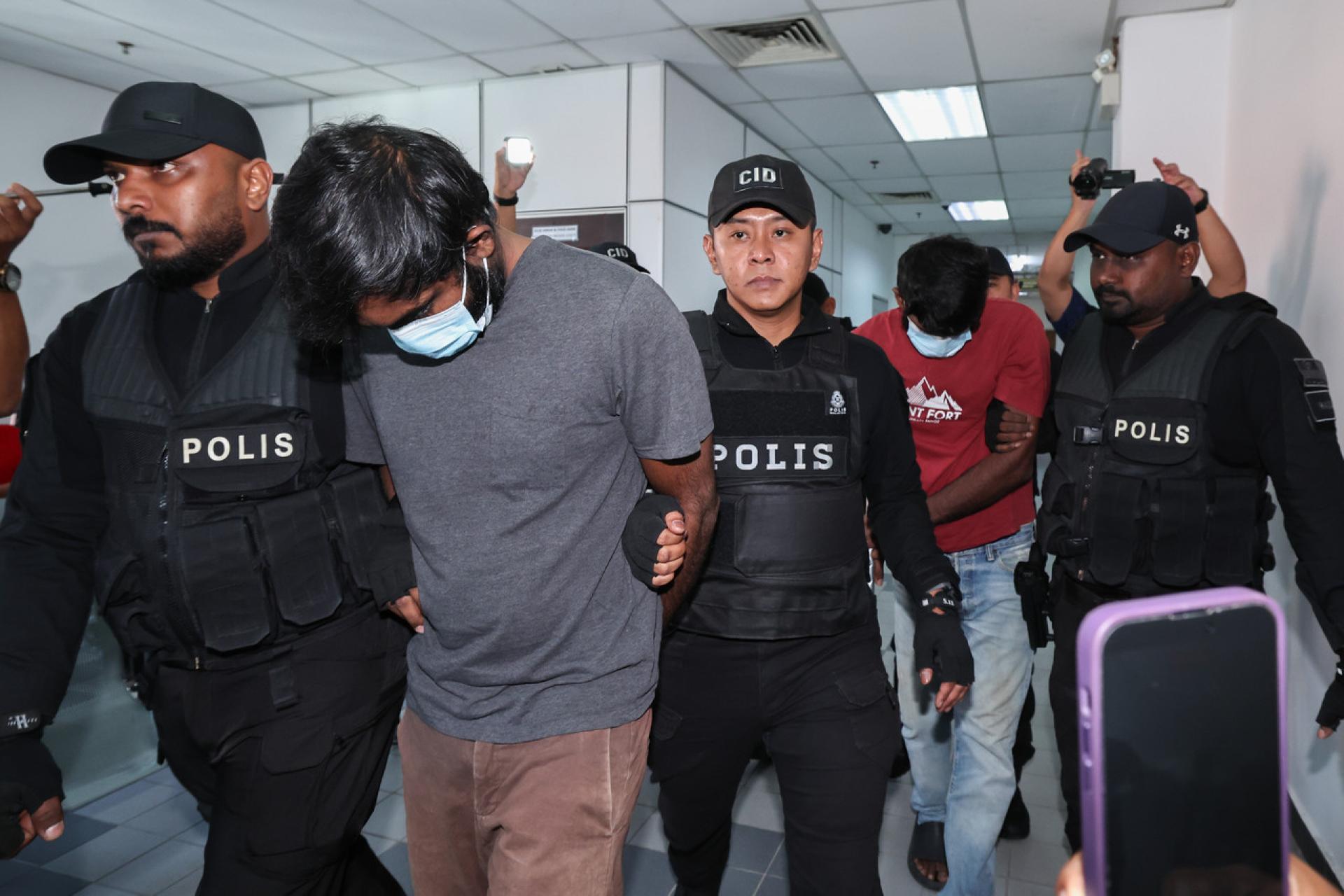 两名嫌犯在大批警员押送下，到法庭面控。（马新社）