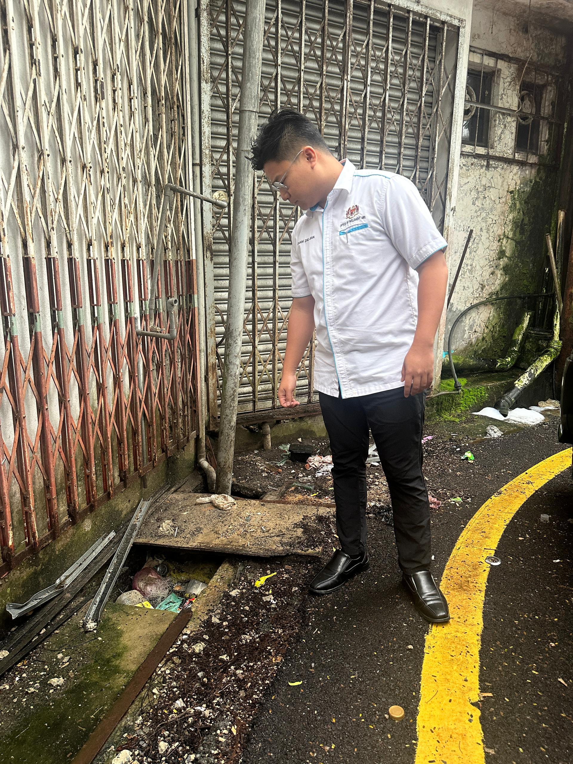 邹梓建巡视富丽华商业区堵塞排水沟，了解垃圾堆积情况。