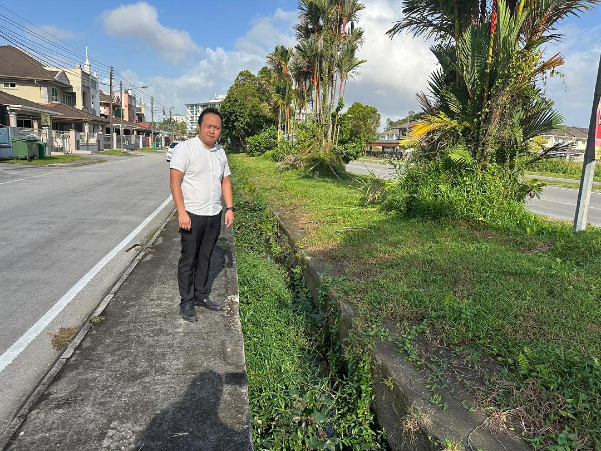 江峰年指着被杂草掩埋的沟渠。