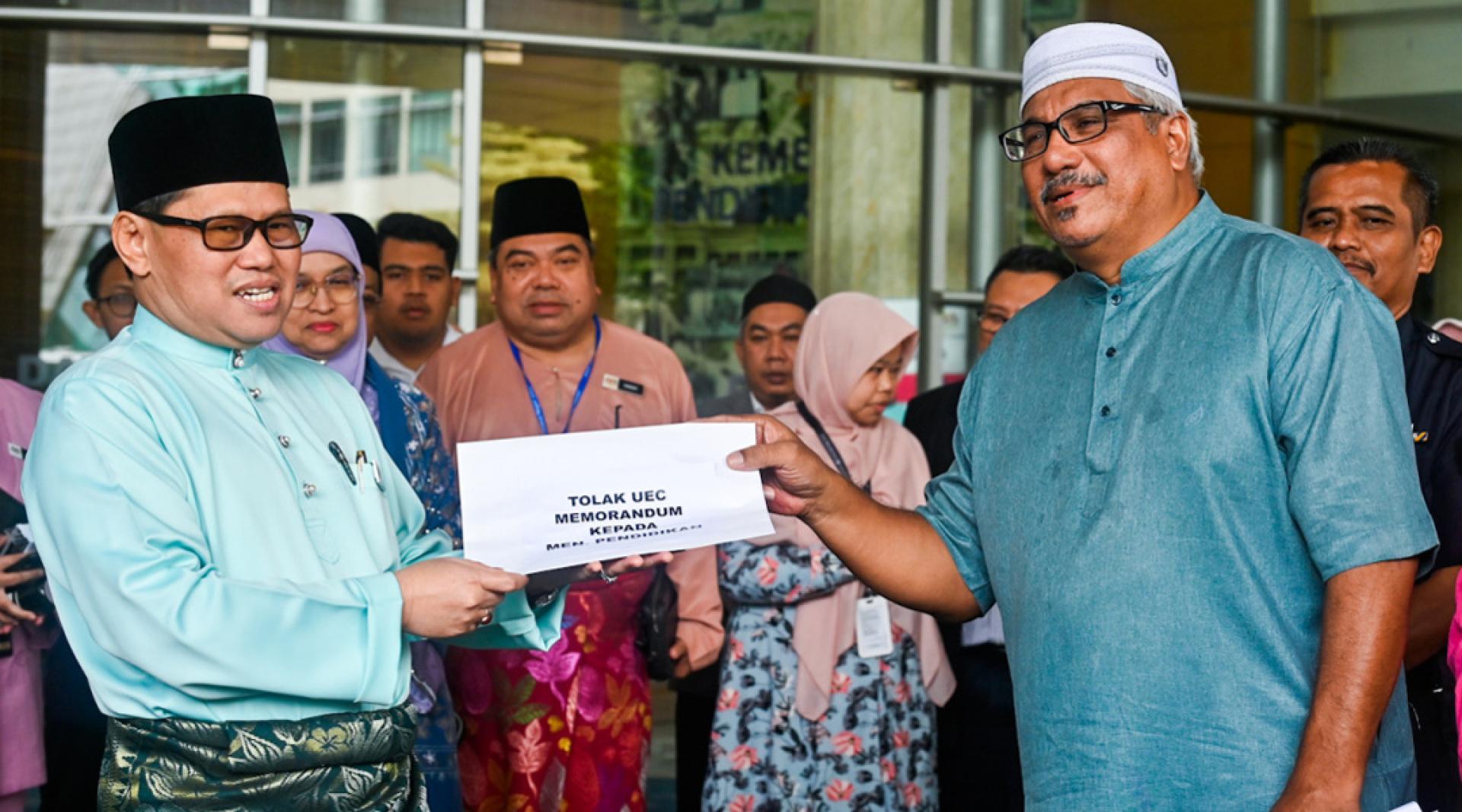 赛益哈山（右）代表32个伊斯兰非政府组织，移交反对统考的备忘录予莫哈末阿占（左）。