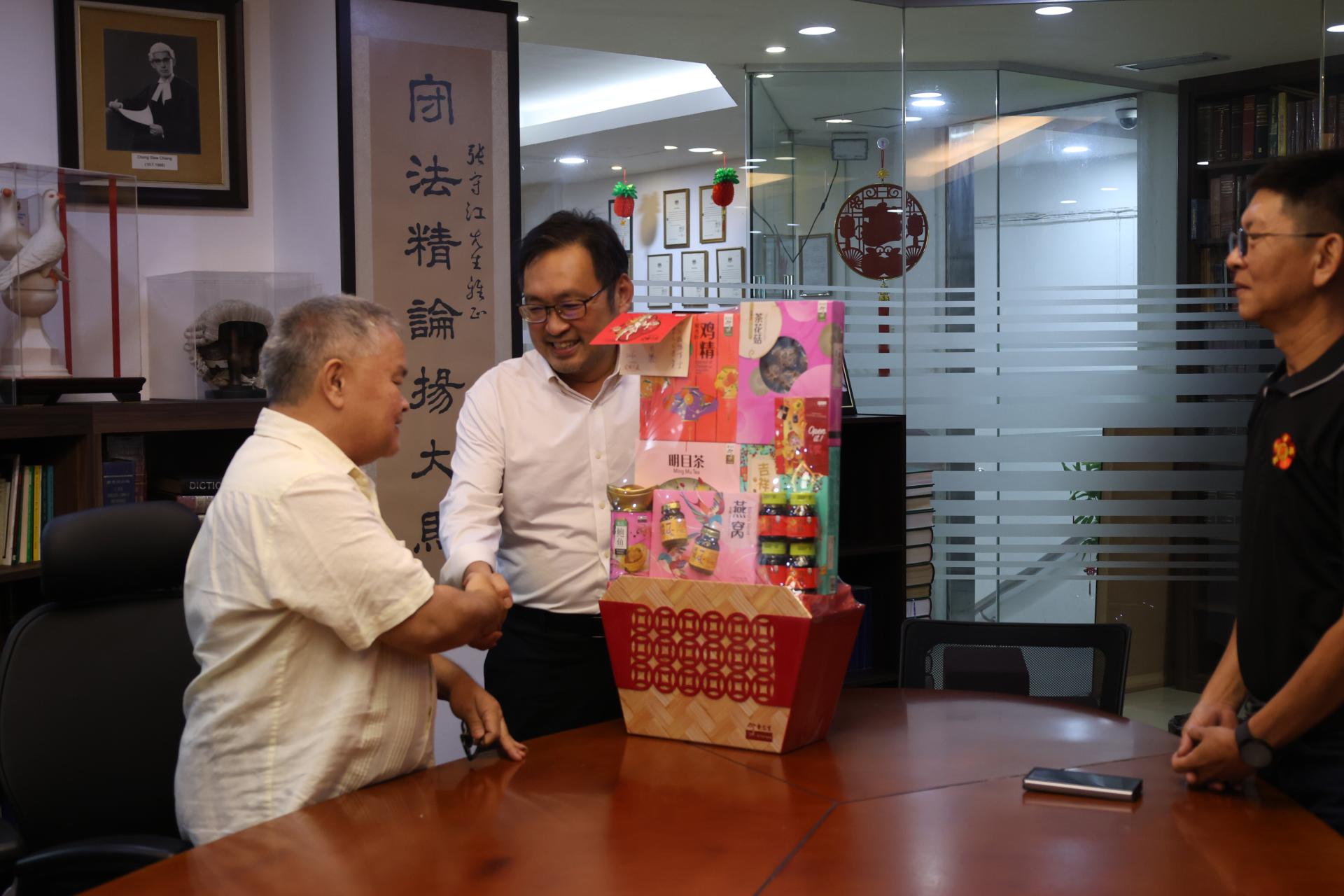 罗如意（左）与罗永发（右）赠送新春礼篮予张健仁，以对其长期以来对公会的关心与支持表达诚挚谢意。