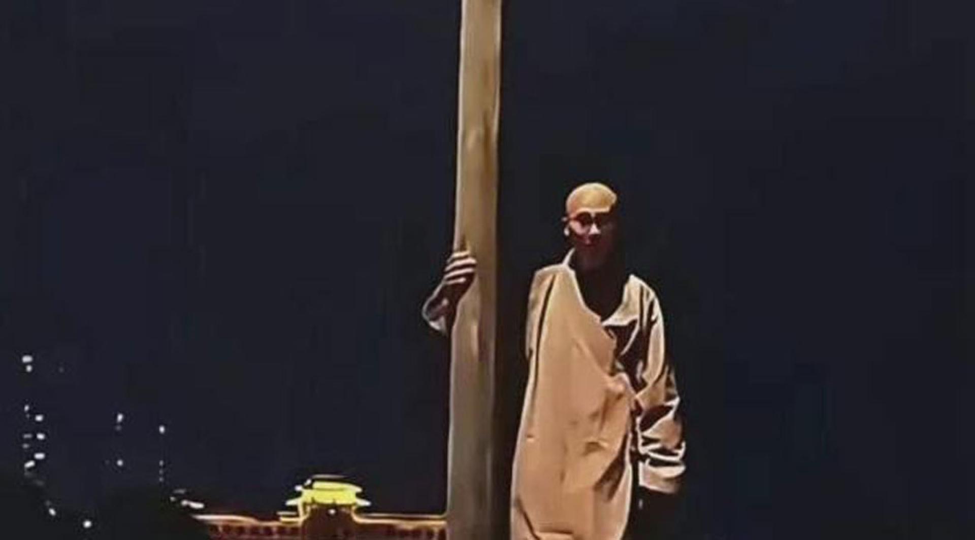 僧人跳江前扶着灯柱，被网友称为“扶灯大师”。