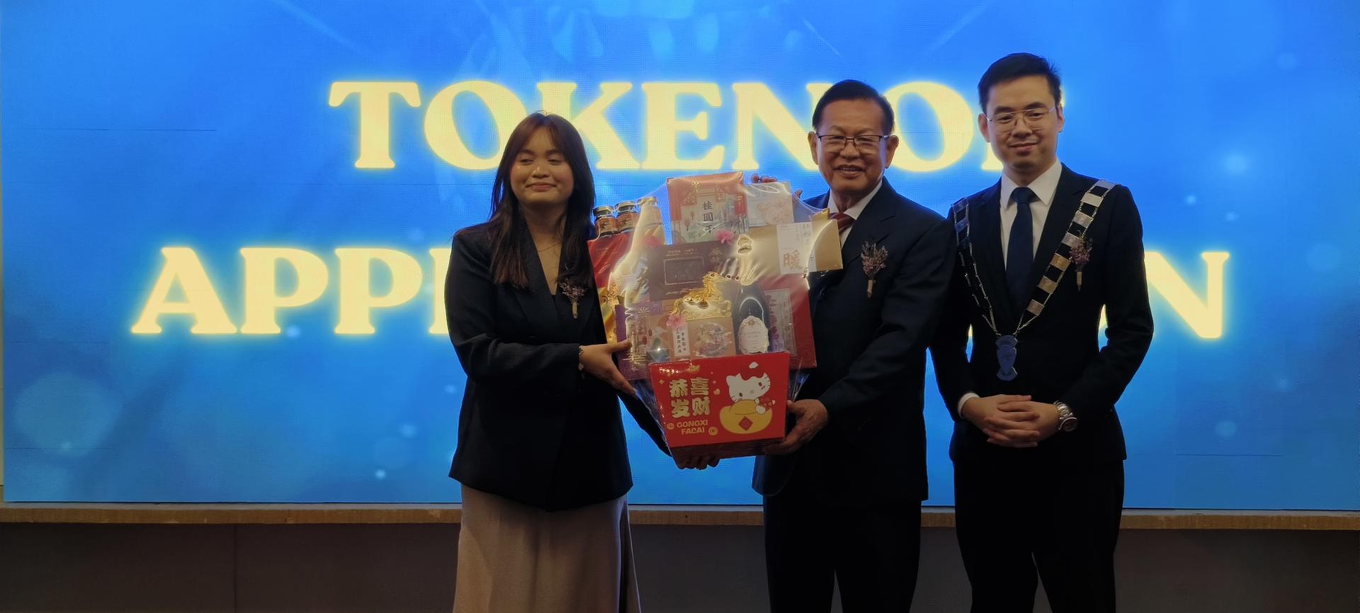 筹备会主席切茜（左）赠送纪念品给主宾砂拉越交通部长拿督斯里李景胜。右为美里国际青年  商会新任会长黄亿明。