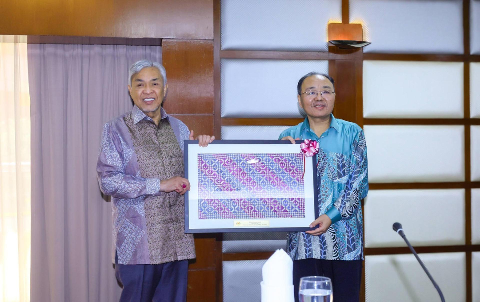 阿末扎希（左起）移交纪念品给欧阳玉靖。