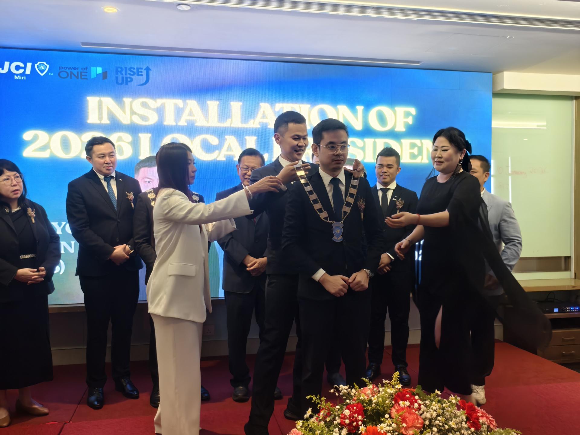 美里国际青年商会年度交接典礼上，卸任会长杨俊能为新任会长黄亿明进行“挂链”仪式。