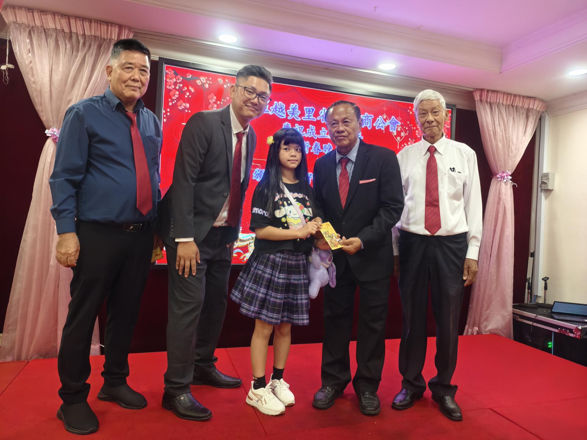 甲必丹严学忠（右2）分发会员子女学优奖励金予其中一名小学组获奖者。