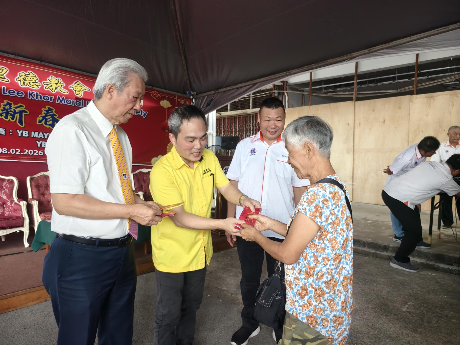 主宾俞小珊的代表张嵻洺（左2）在紫理阁阁长贝清湛（左）及筹备会主席王武德（右）陪同，分发新春布施活动红包予受惠者。