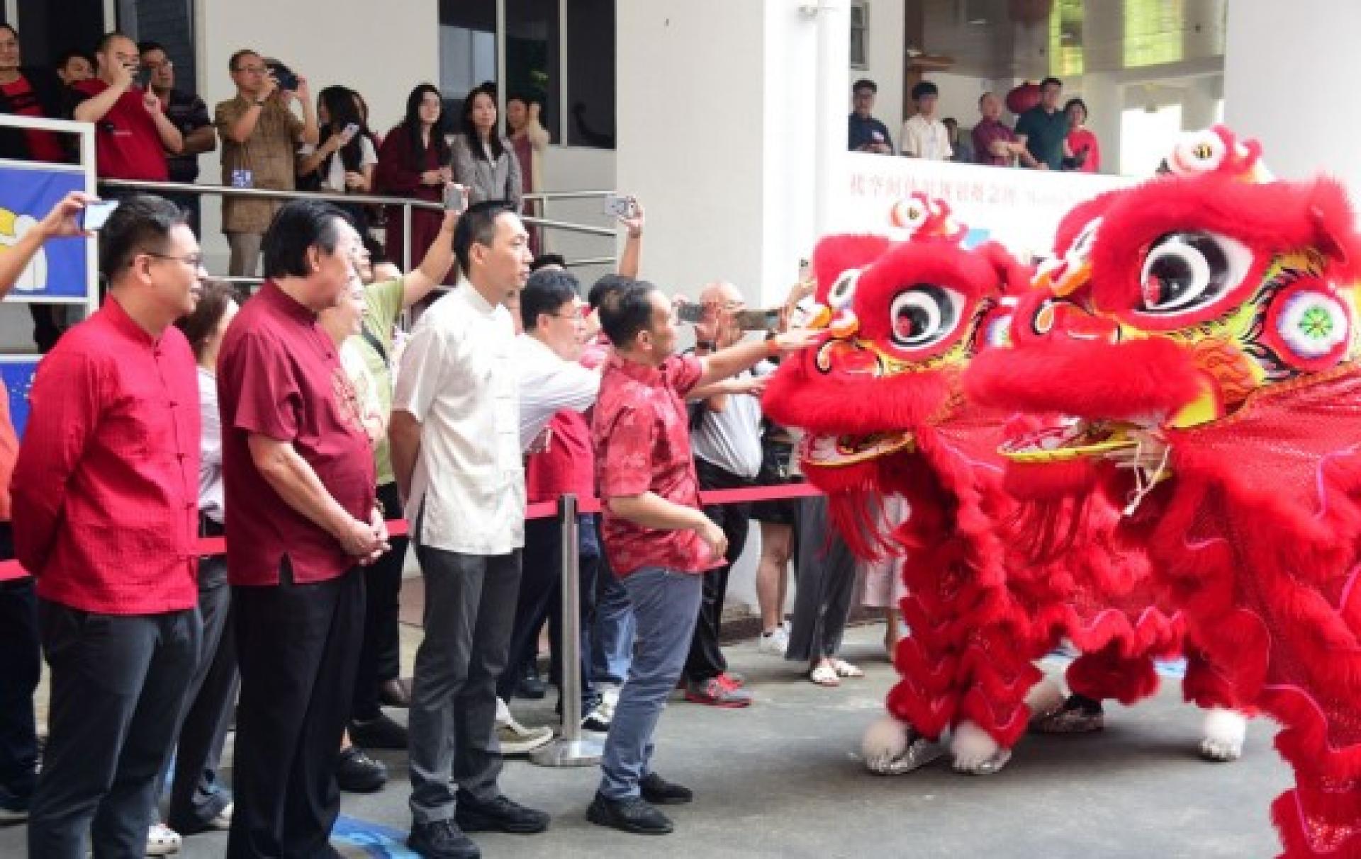 谢瑞詹（左4）在舞狮表演后，上前抚摸狮头，沾一沾新年喜气。