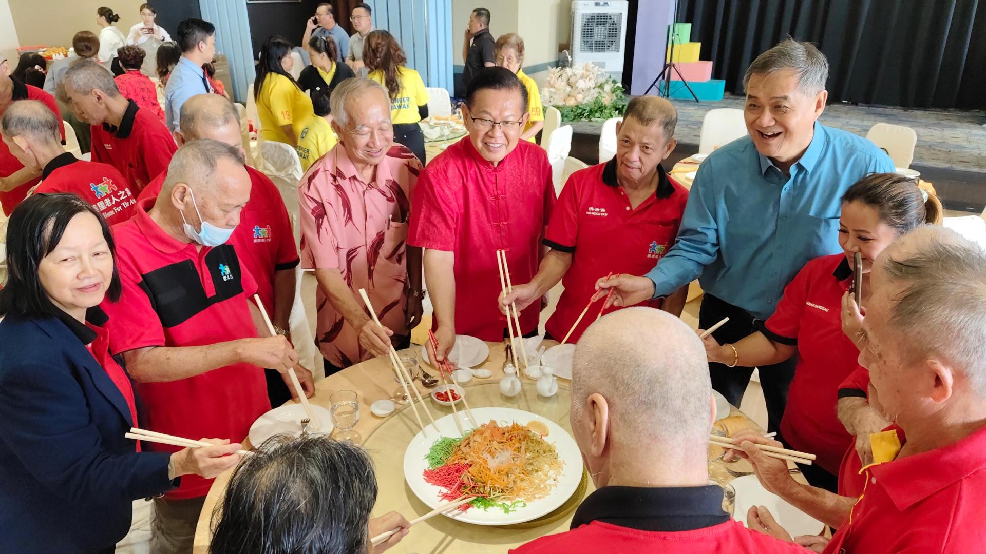 砂交通部部长拿督斯里李景胜（左4）与美乐酒店董事经理刘秉德（左6），与老人之家年长者一同撈生，欢庆新年。