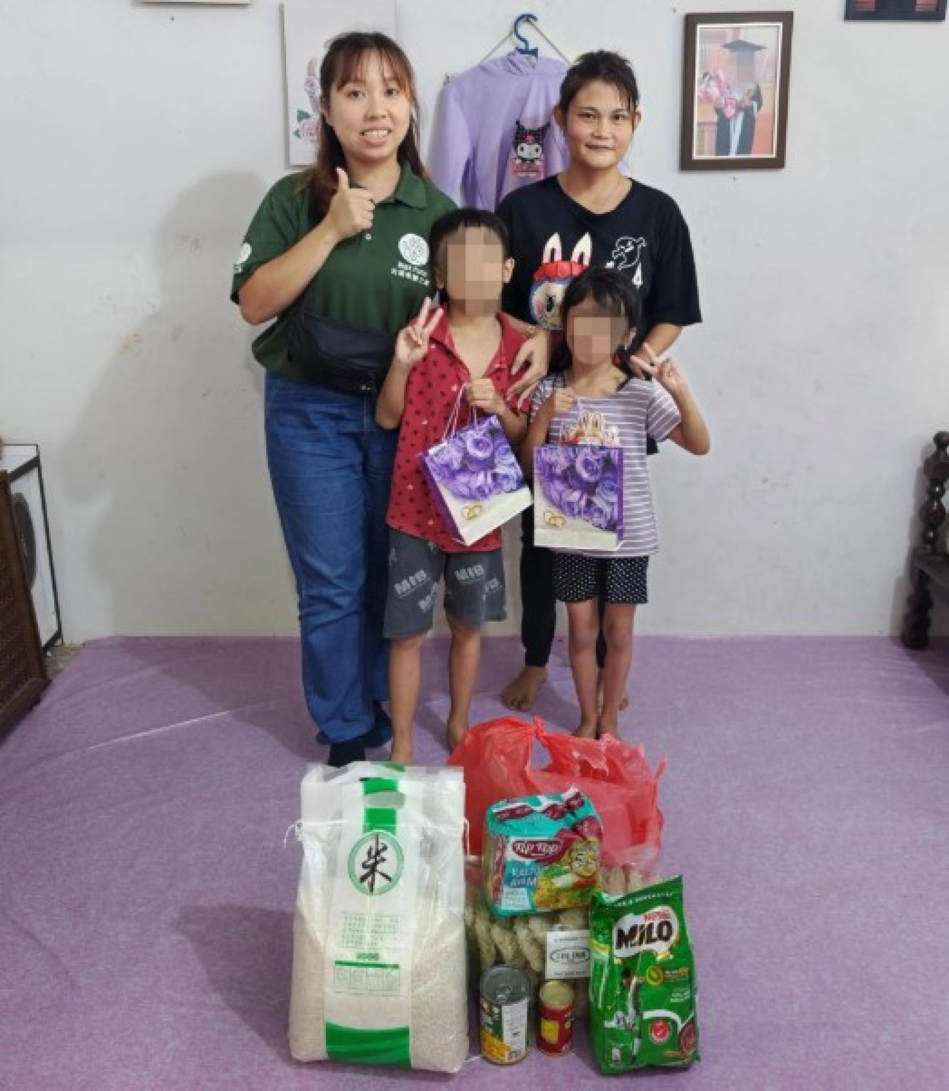 希望之家代表 Mary Vun（左）与约瑟芬及其孩子合影。