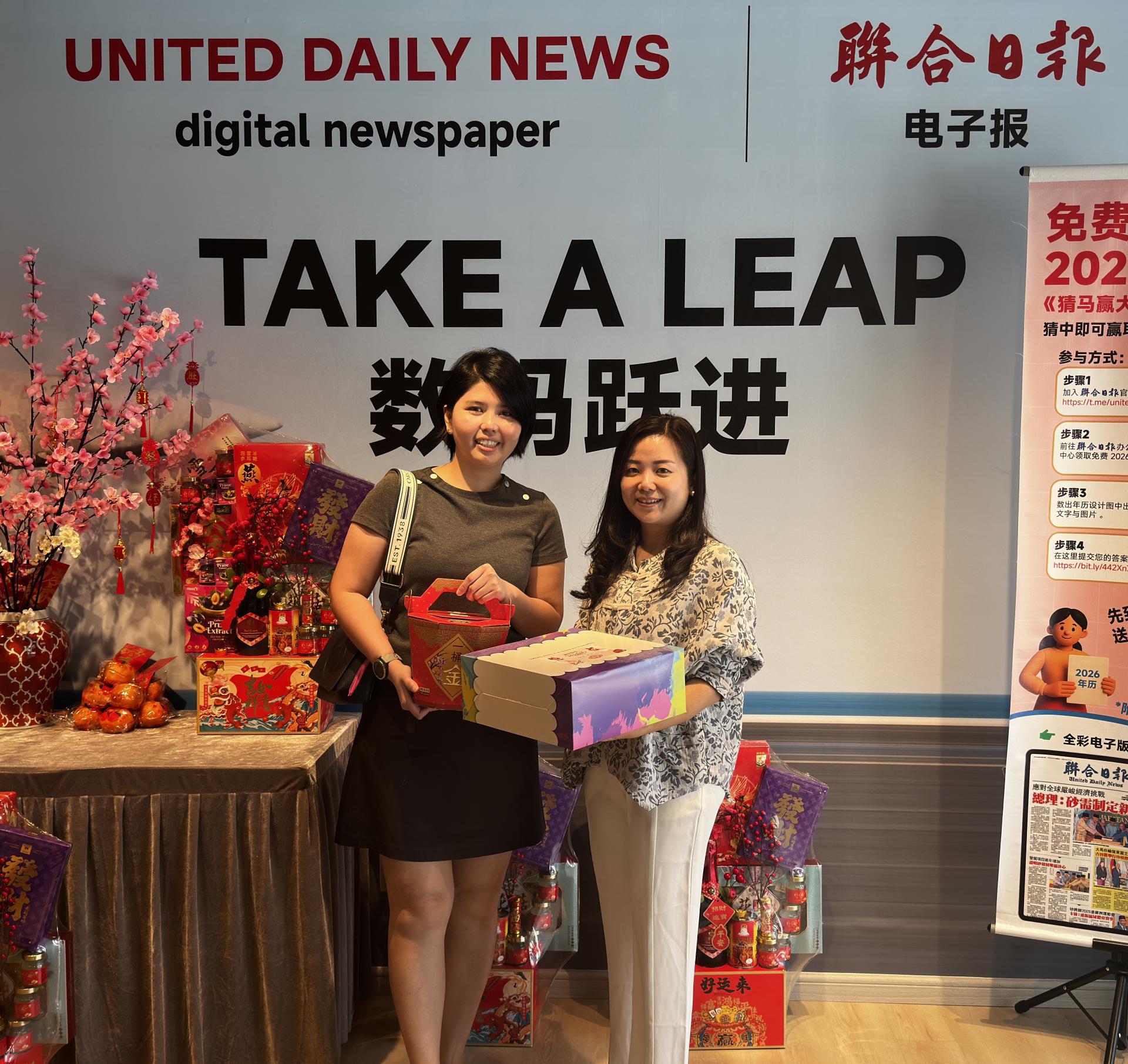 贝园酒店助理销售及公关经理方爱华（左）移交红柑与佳节蛋糕予联合日报总经理田可慧时影。